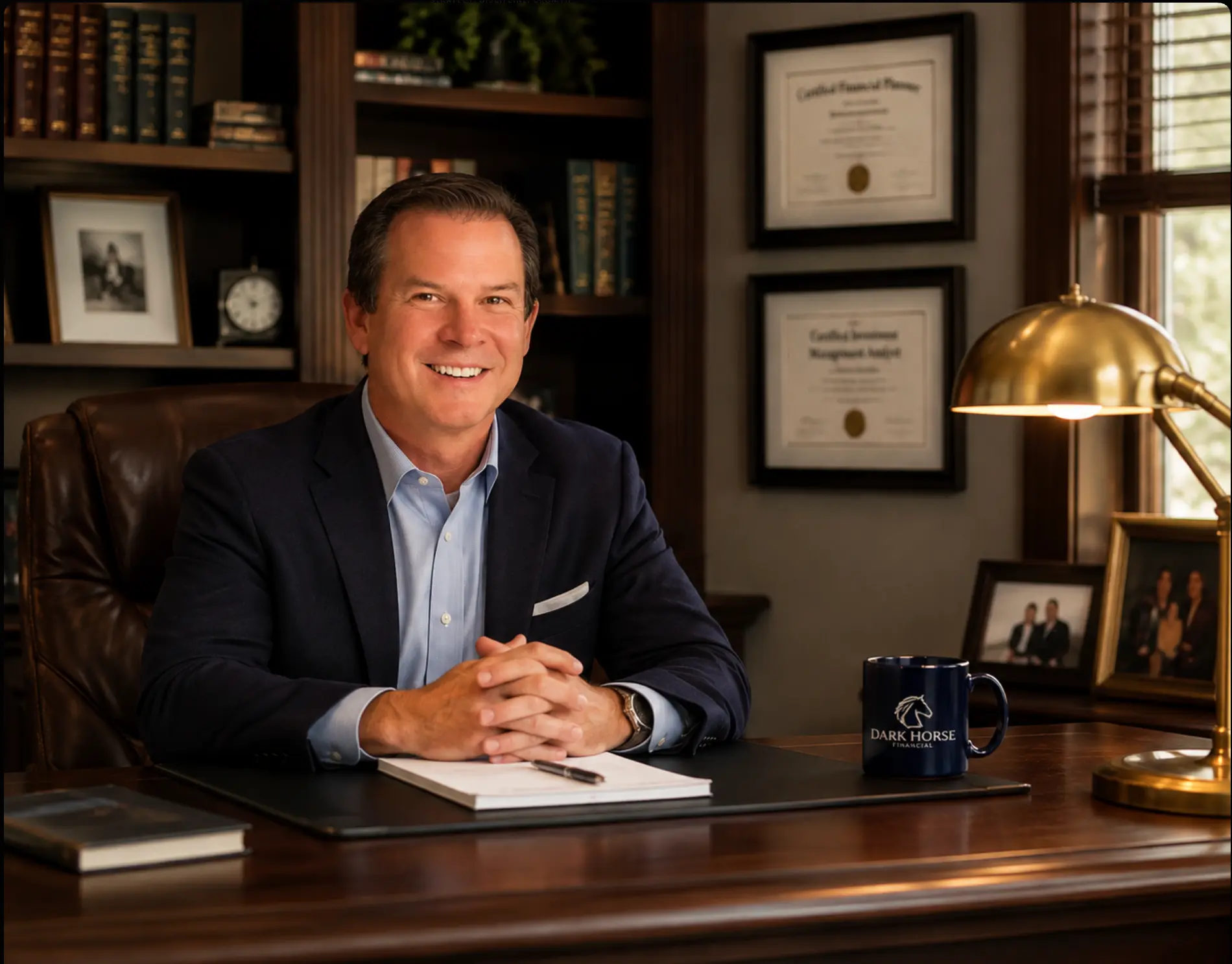 Financial advisor seated at a polished wood desk in a traditional office with brass lamp and credentials
